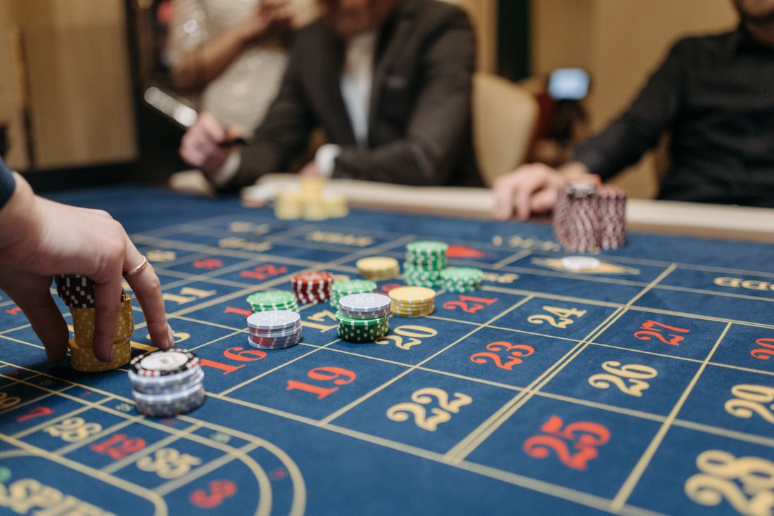 Tangan pemain menempatkan chip kasino di atas meja roulette
