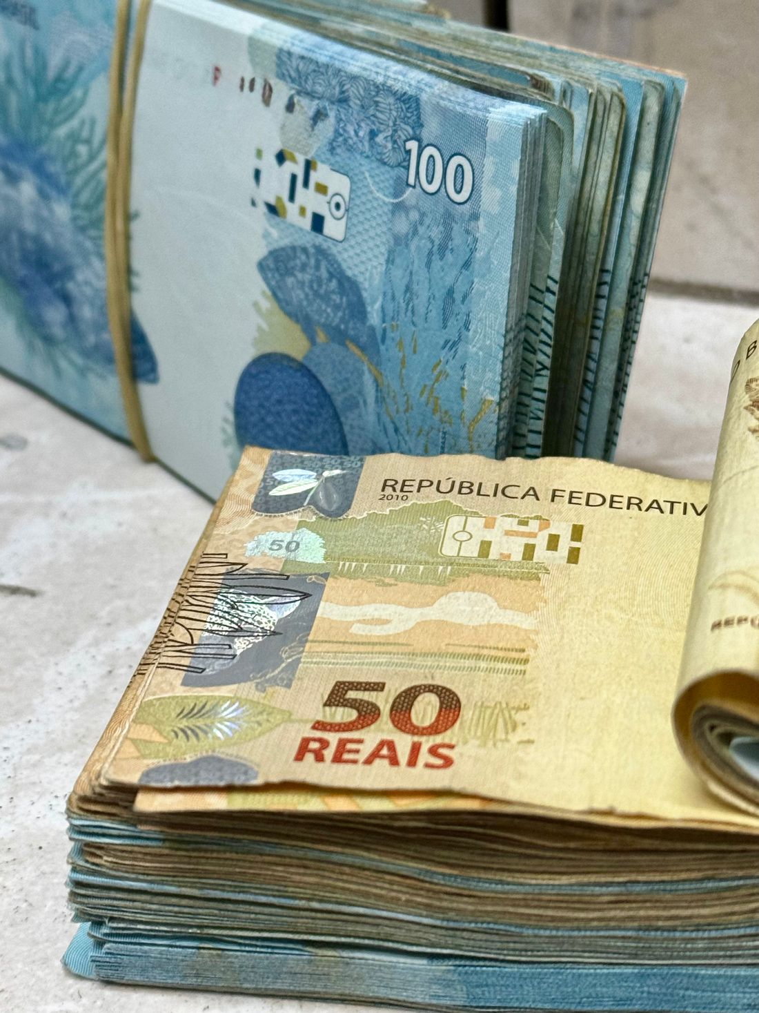 Sejumlah uang tunai rupiah dengan perangkat digital di sekitarnya
